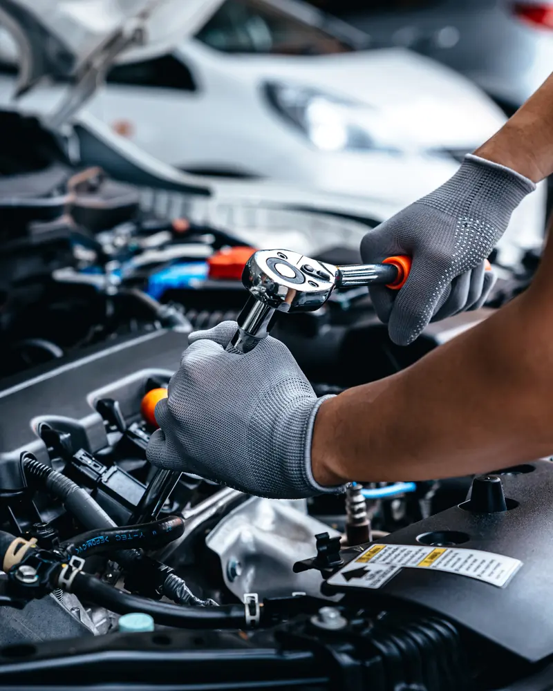 Technician fitting engine parts with a ratchet