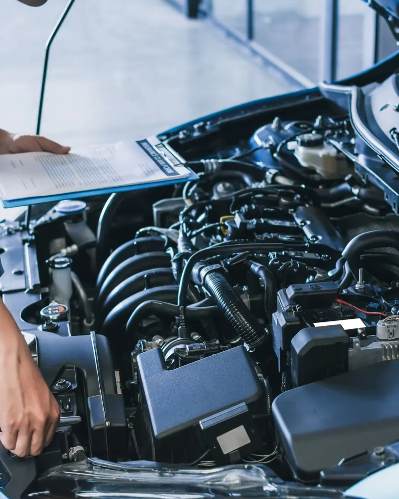 Engineer with an inspection checklist assessing an engine for a rebuild quote